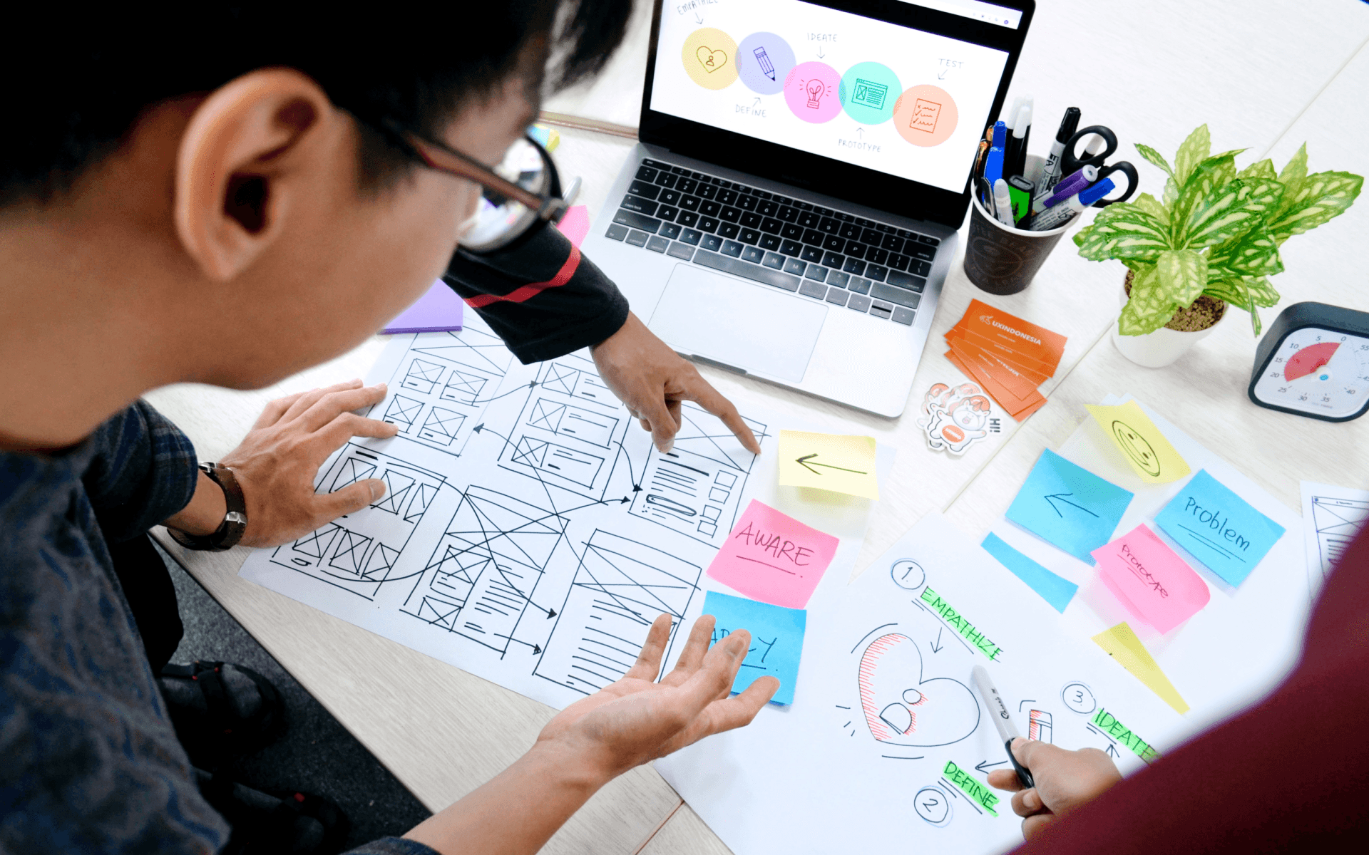 Group of professionals engaged in project planning for a Jamstack WordPress website, focusing on wireframes and strategic layouts, with detailed diagrams and planning documents spread across their workspace.