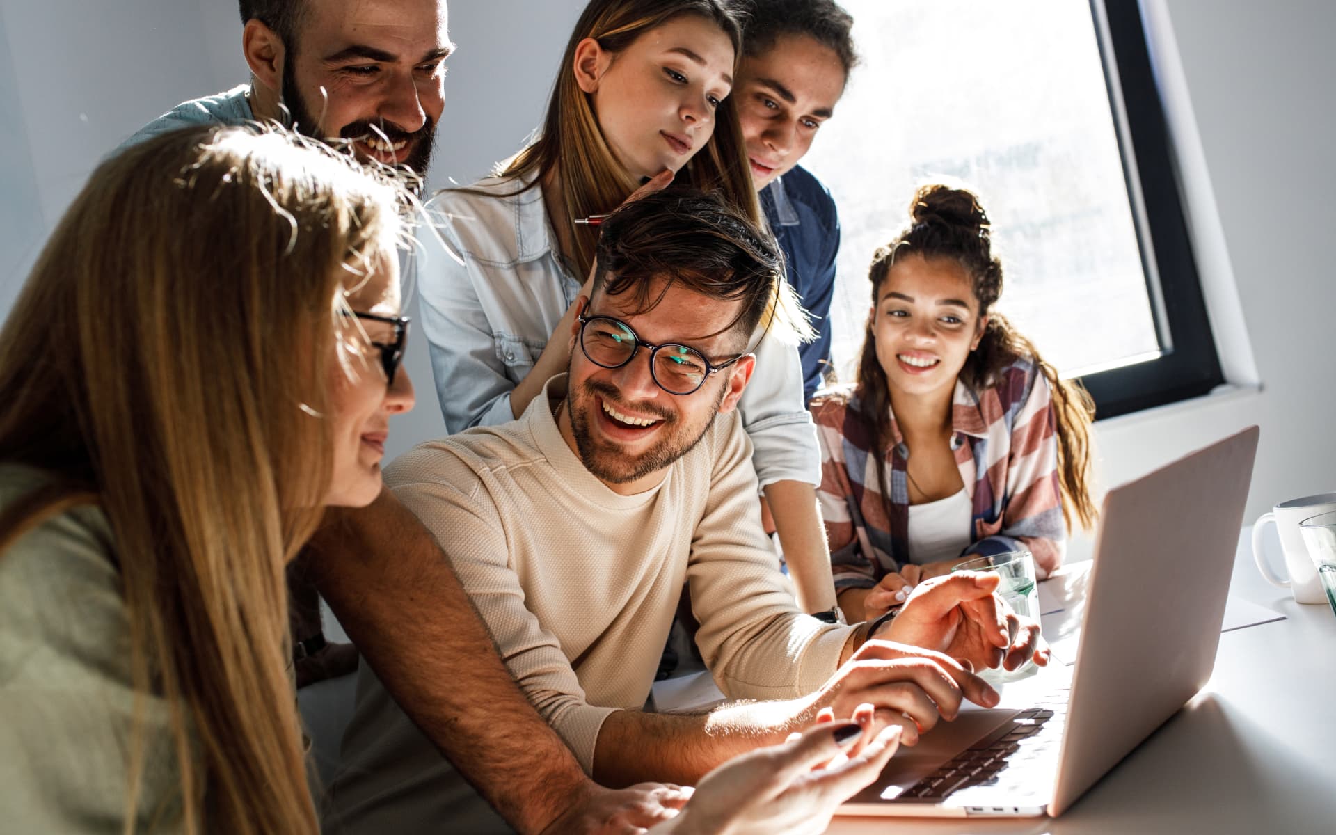 The team collaborating on a laptop, discussing custom WordPress themes vs. templates for a website