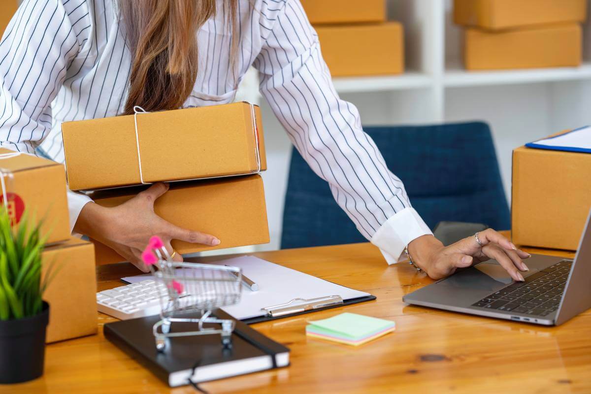 Small business owner managing eCommerce orders and working on a laptop